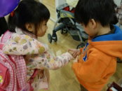 Two young children holding hands indoors.