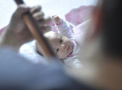 toddler lying on bed with comforter